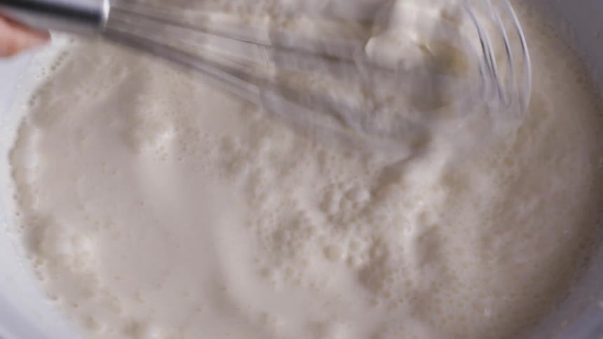 A person is stirring ingredients in a bowl