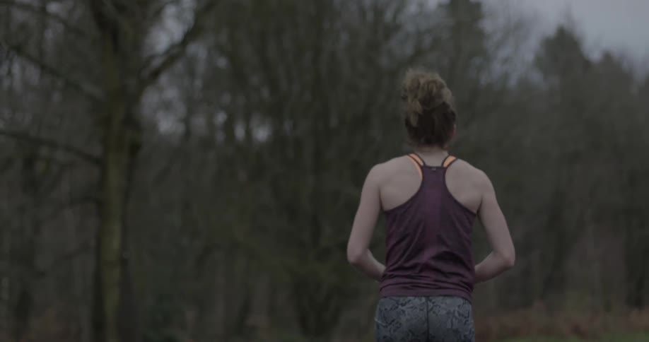 A female jogger pauses to catch her breath during a run