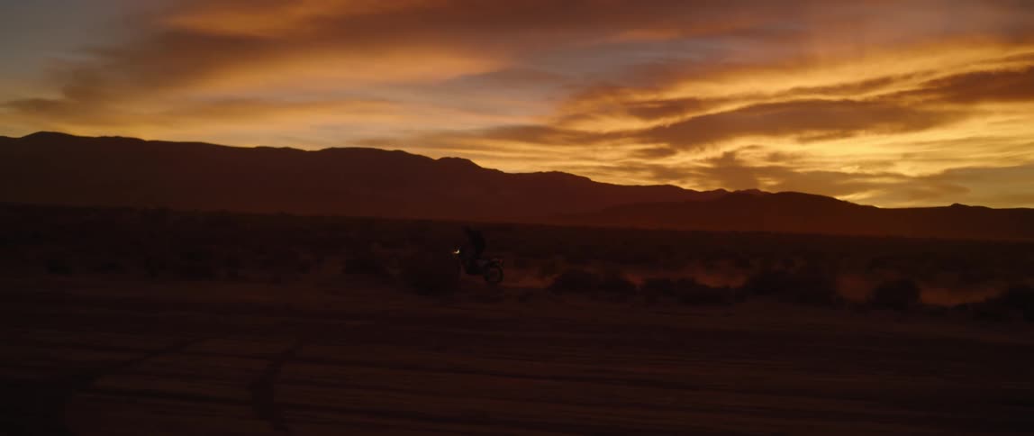 A person riding their motorcycle over a dirt road