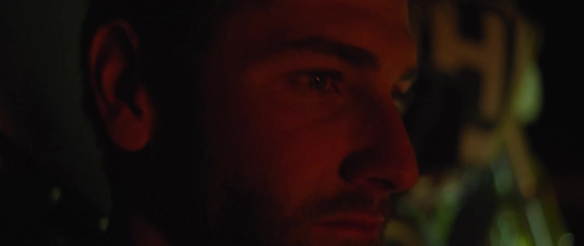 Man with a stubble beard looks at a red light