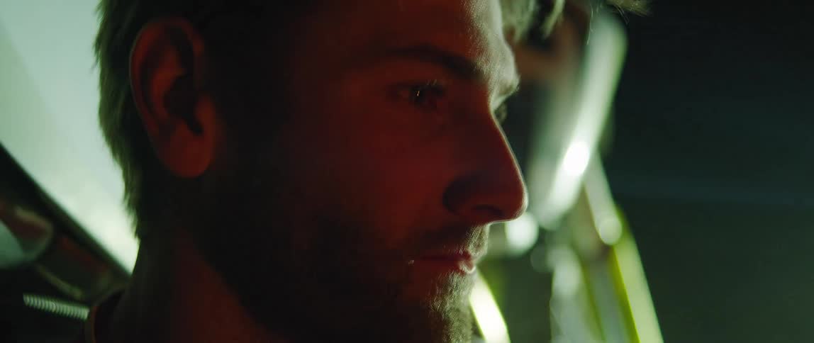 The light flashes on a man sitting by the vehicle