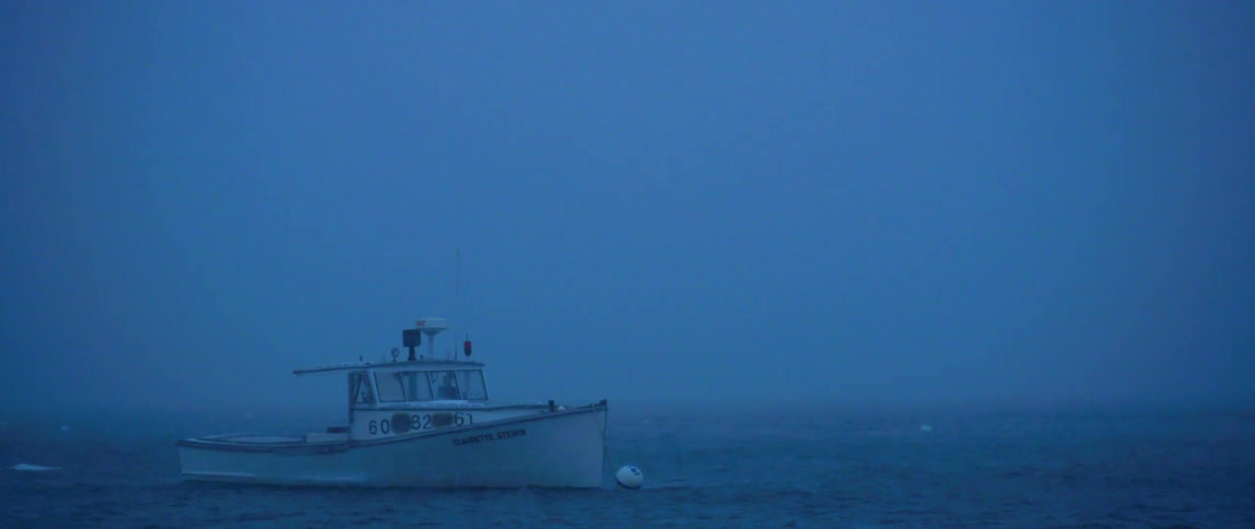 A small fishing boat weathers a winter storm in a bay