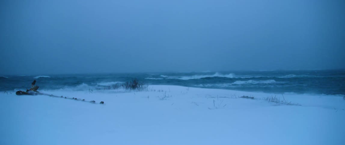 Snow and sea spray blows in the wind of a winter storm