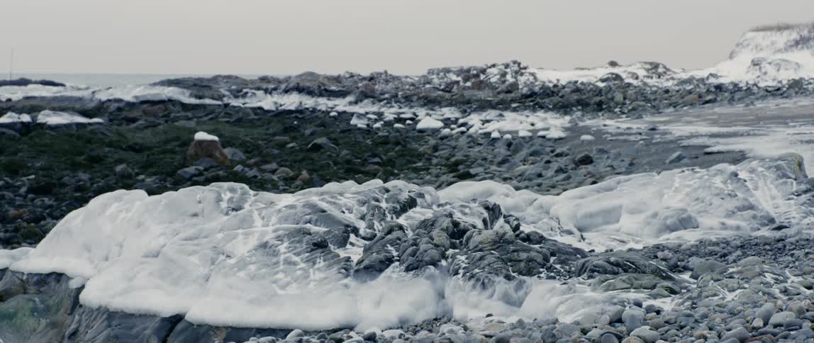 Ice and snow cover the rocky shoreline of Maine in winter