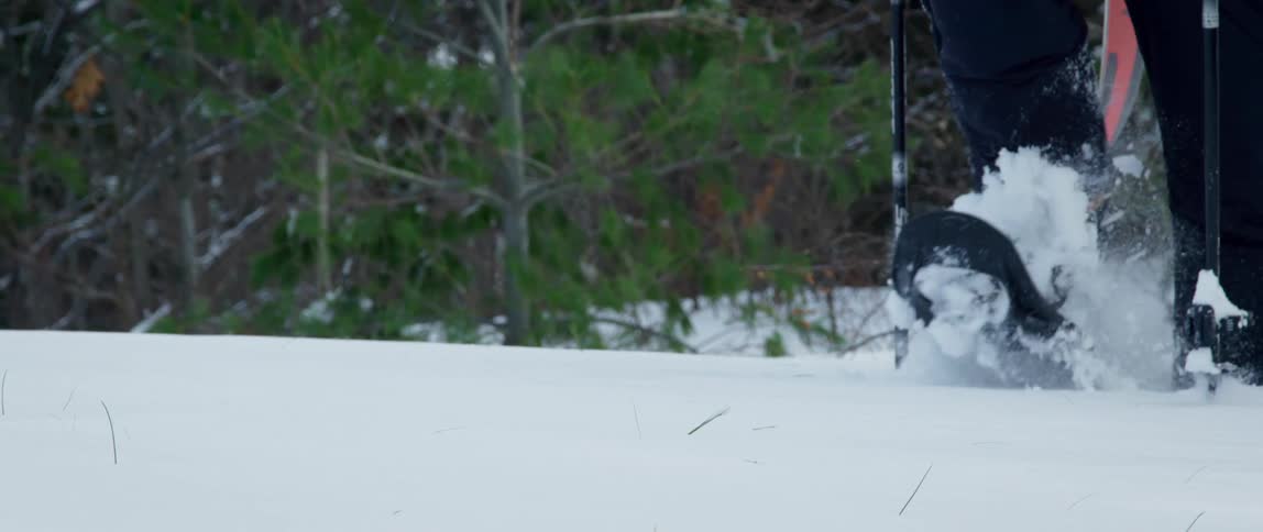 A man takes a big step through deep snow