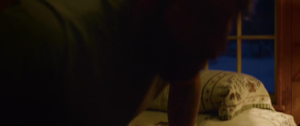 A man sits up in bed and takes a deep breath