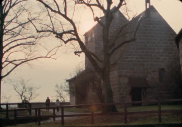 A couple walks to a stone chapel in the Imperial Castle grounds of Nuremburg.
