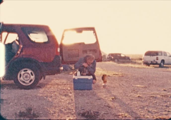 A man makes camp coffee at sunrise