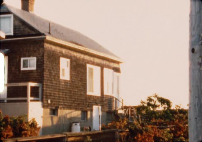 A beach house stands in the morning sunlight on the coast of Maine
