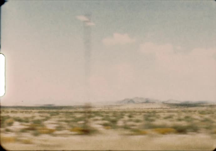 A mountain range sits on the horizon of desert grasslands