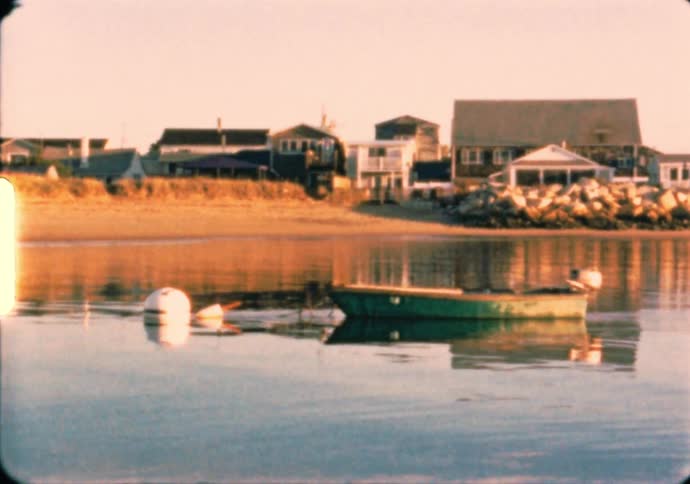 A small dinghy boat tied to a buoy floats in a lagoon in Maine