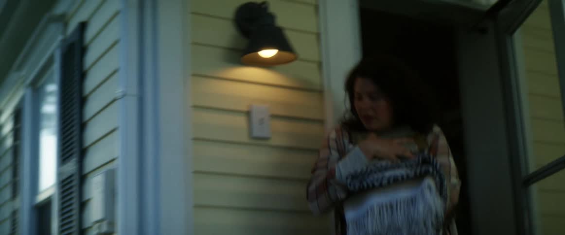 A woman races from her house to the barn with sheets