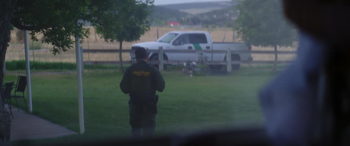 A police officer walks back to his truck from a home