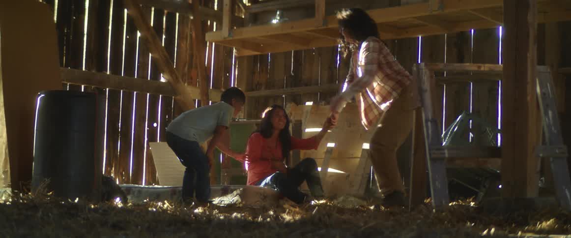 A woman runs to get help as a woman goes into labor in the barn