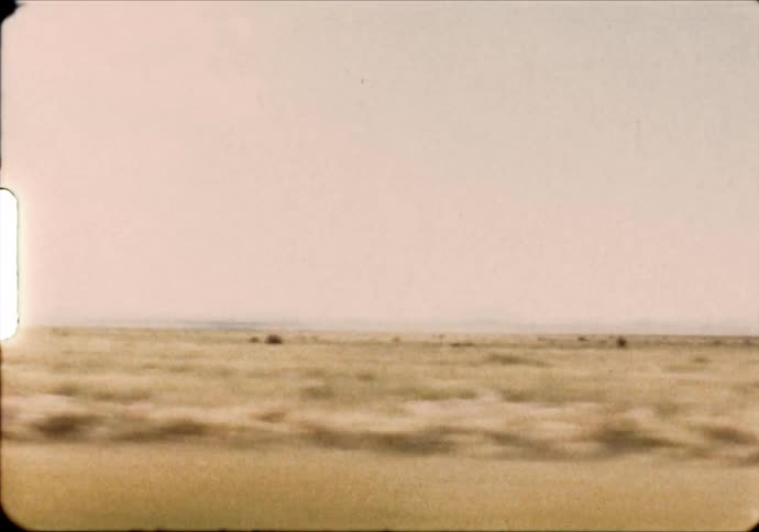Passing through grasslands with mountains on the horizon