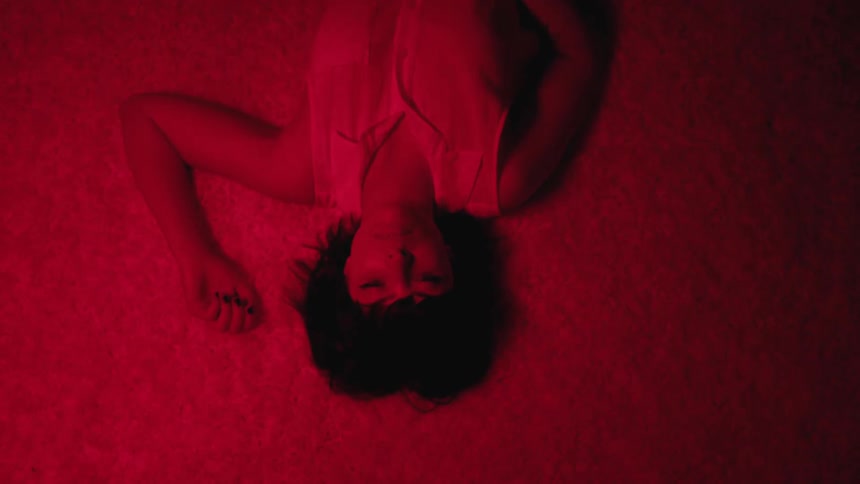 A woman is laying on the ground at night