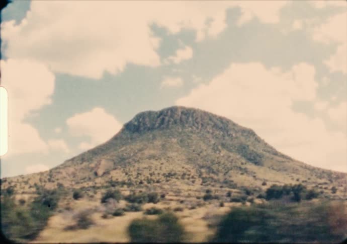 A mesa rises out of the passing grasslands