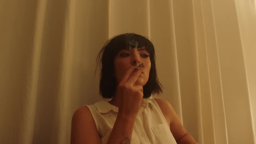 A woman is smoking a cigarette indoors