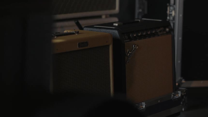A man walking past two amplifiers