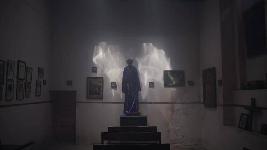 A statue in a room with art work on the walls