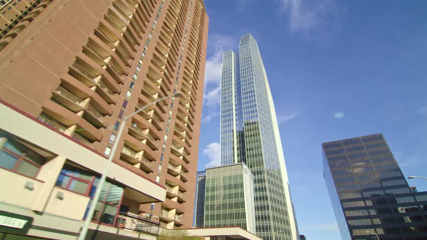 Apartment buildings are nestled between tall skyscrapers in a city