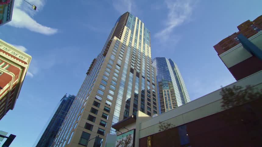 A city with traffic lights buildings and skyscrapers with the sky and clouds above
