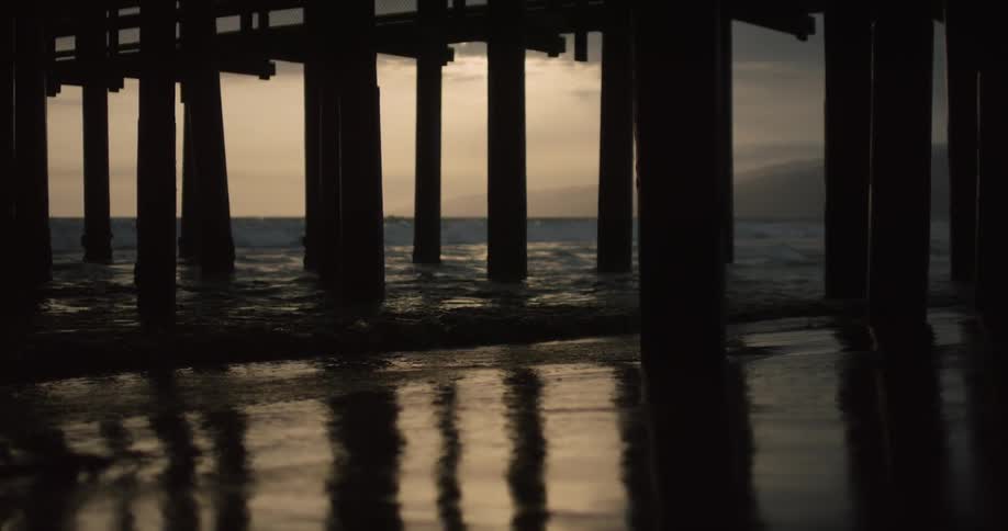 Ocean waves flow beneath a pier