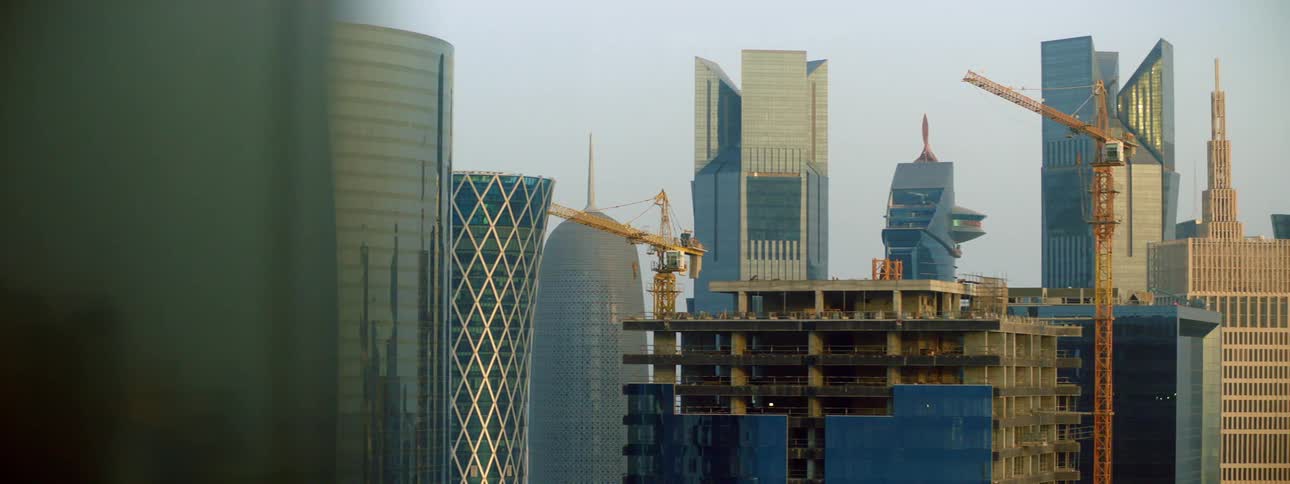 Cranes are around the tall buildings under construction