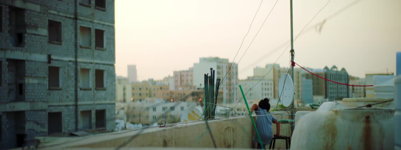 A child sits on a chair on the roof
