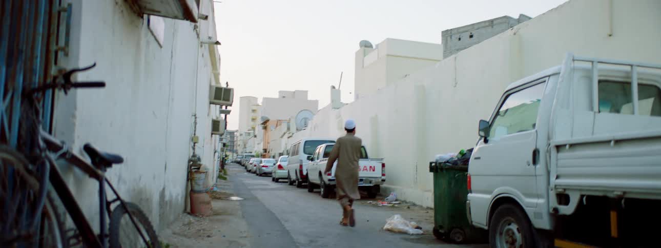 A man walks down the alley on a cloudy day