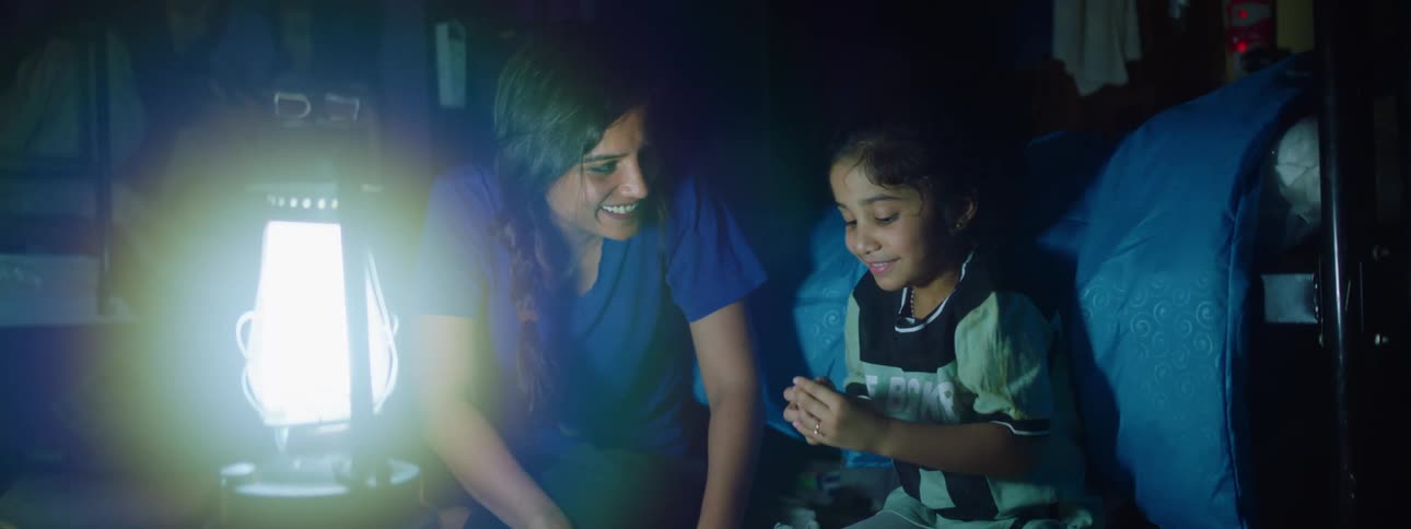 A mother and daughter have fun near the lamp