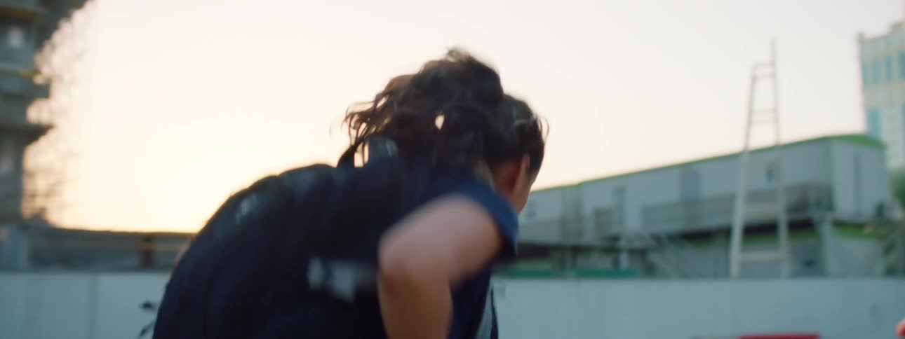 A young girl runs past a construction zone in a city