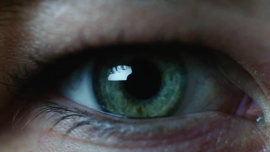 A woman opens up her eye and blinks while staring straight ahead