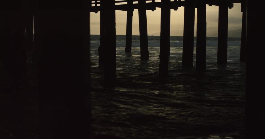 Water flows around pillars near sunset