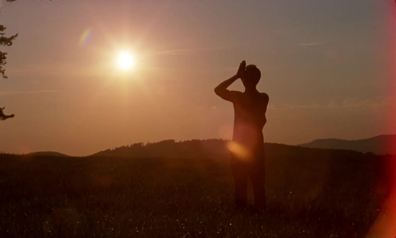 Silhouette of a person meditating mountain top at sunrise