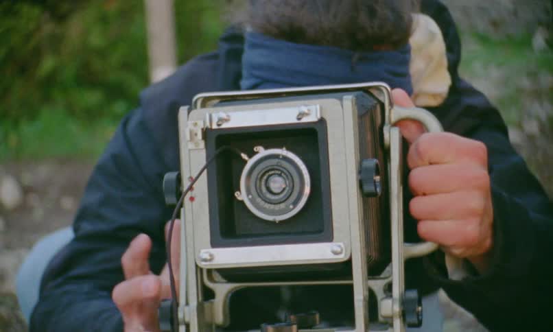 A man is setting up a camera on the mountain