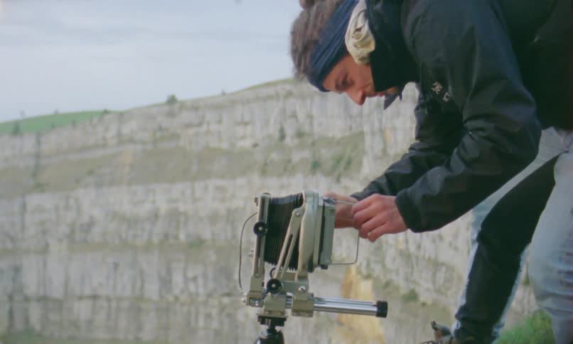 A photographer is setting up his tripod