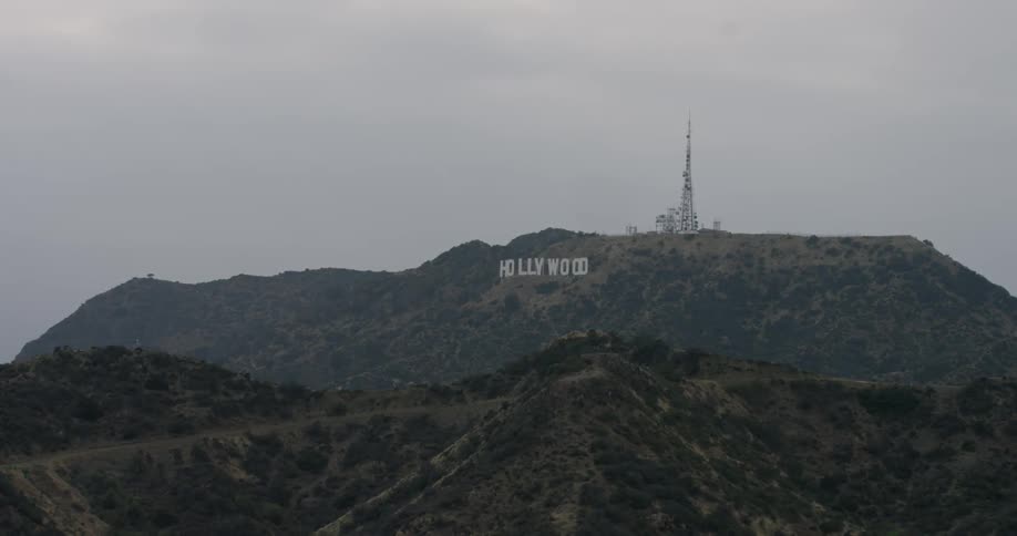 The hollywood sign sits in the distance on a cloudy day
