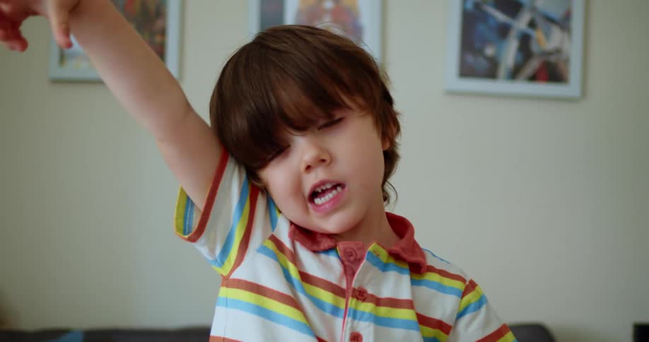 A young boy playing in the living room of a house