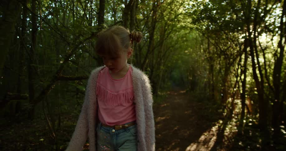 Young girl walks through the forest on a sunny day