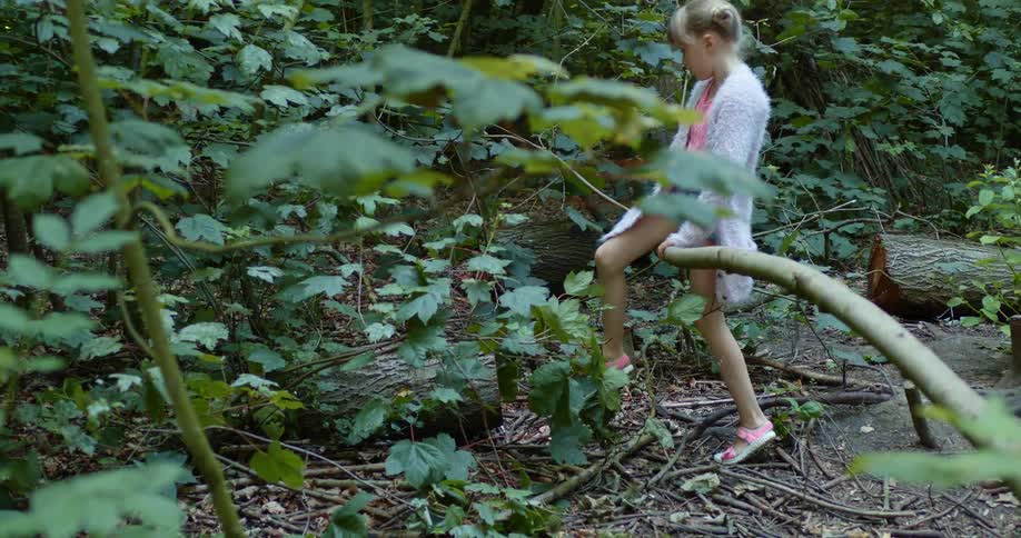 A girl is walking through a wooded area