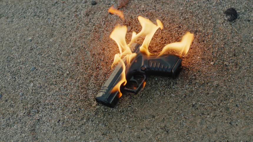 A gun is displayed and is on fire