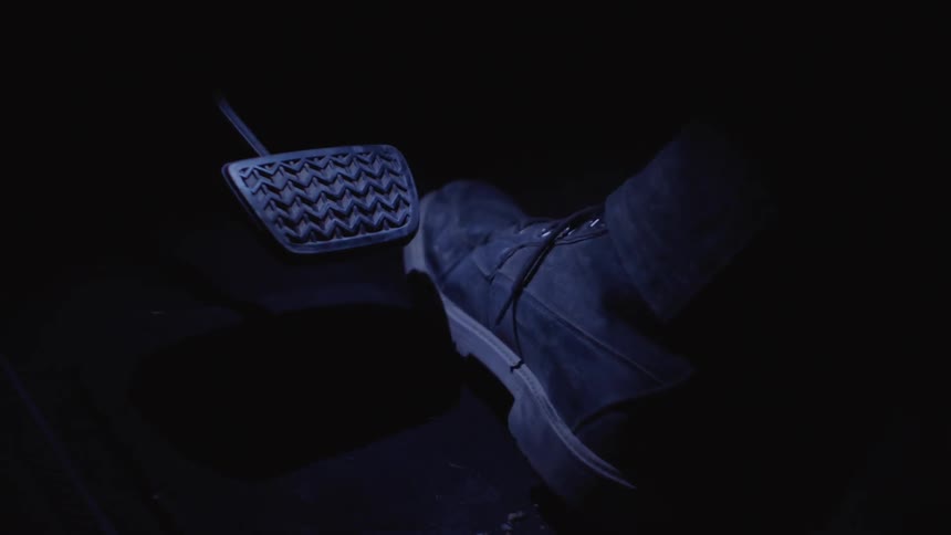Close up of foot pressing the brake and acceleration pedals on a car