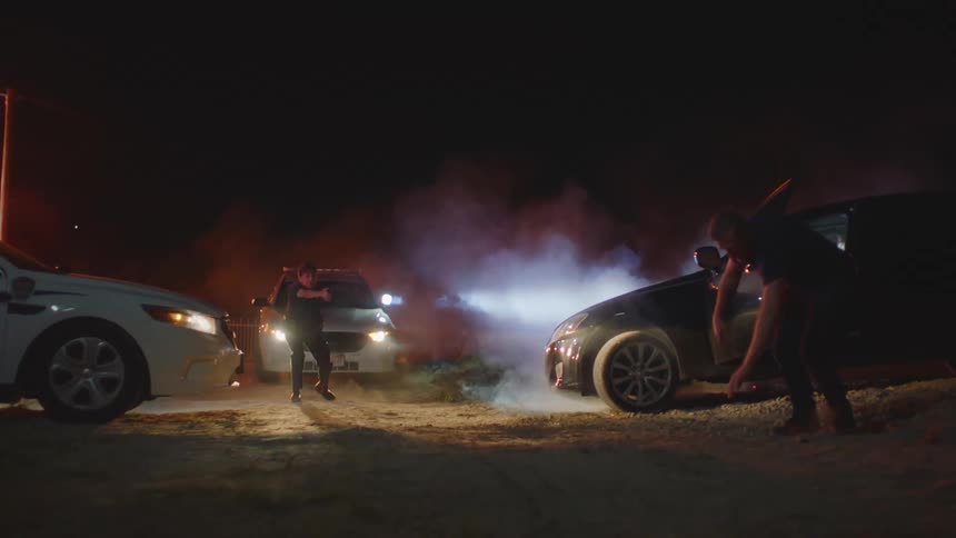 Man exits a vehicle as the police approach to arrest him