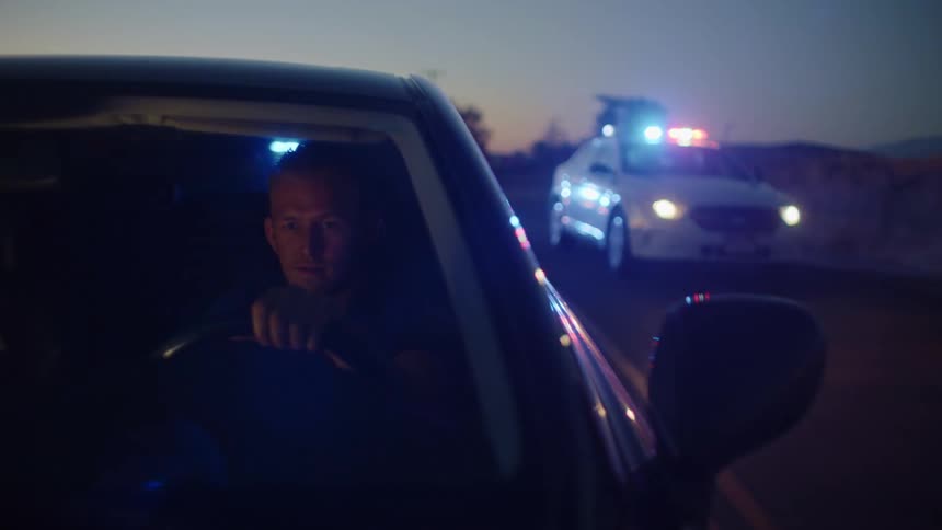A man tries to drive away from two police cars chasing after him