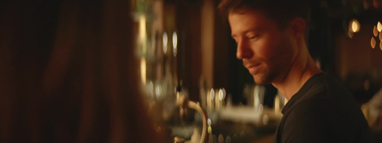 Man nods his head at the bar then turns to walk away