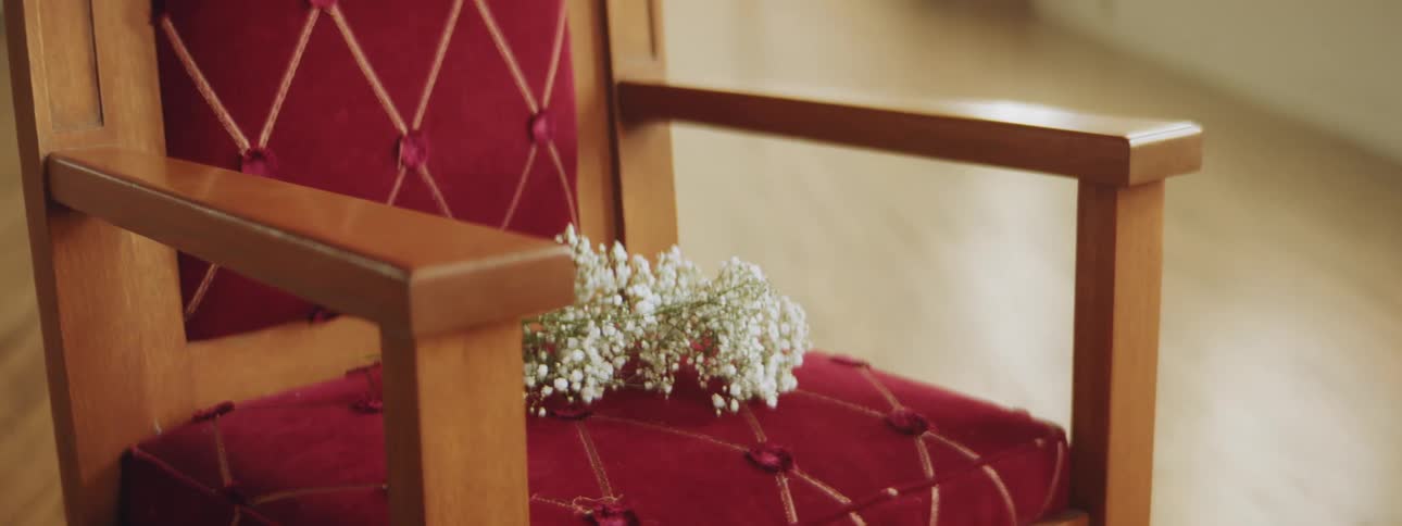 A chair with flowers on it with a wooden floor in the background