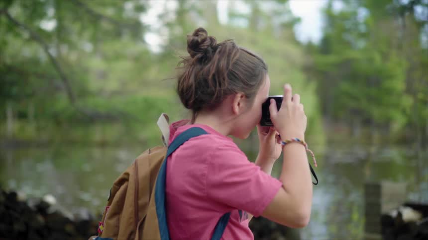 A girl is taking photos of the lake