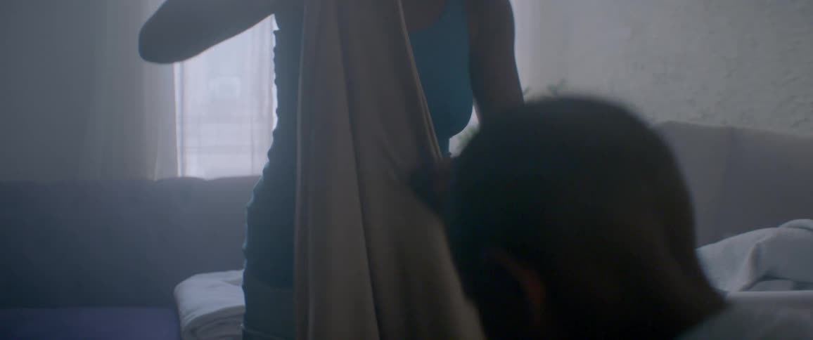 A woman pulls a blanket from a laundry basket
