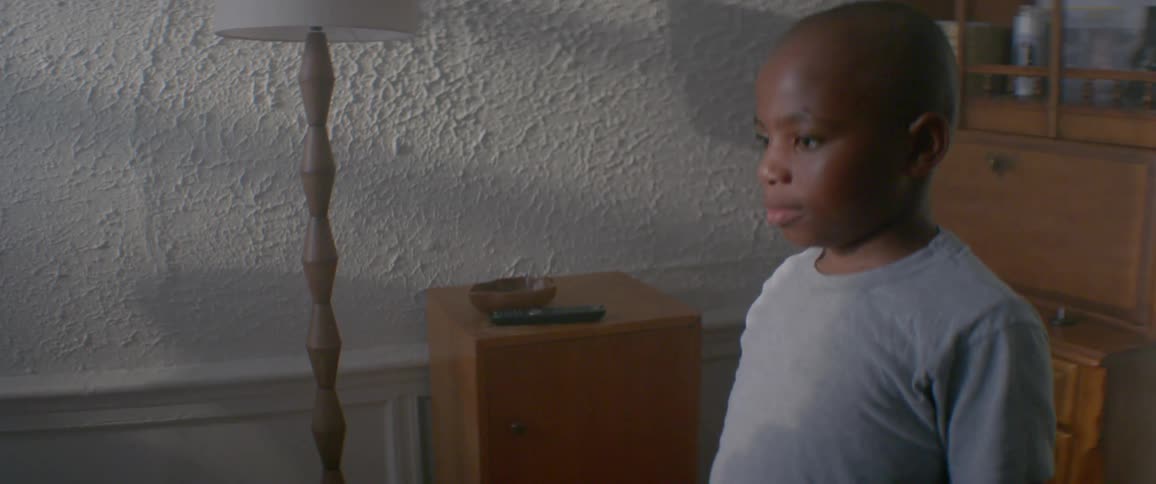 Boy helps his mother fold a towel